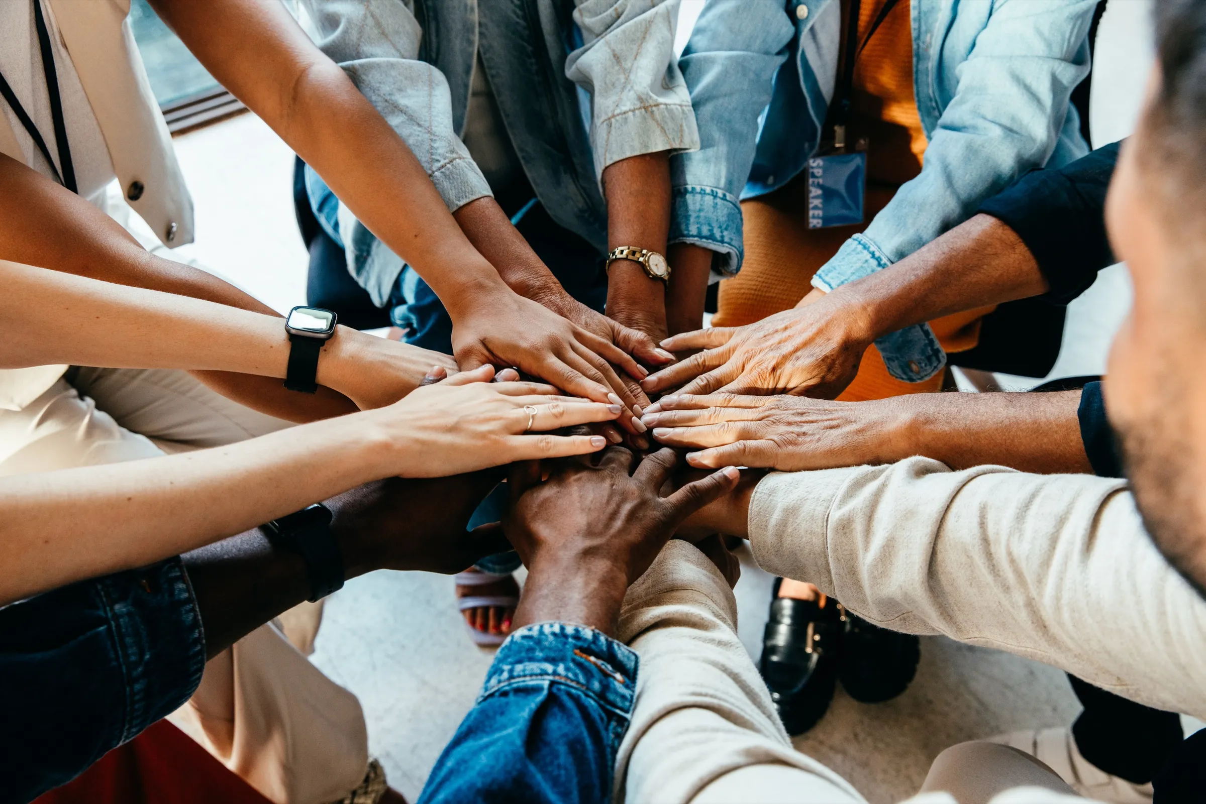 A circle of hands stacked together, a team working as one