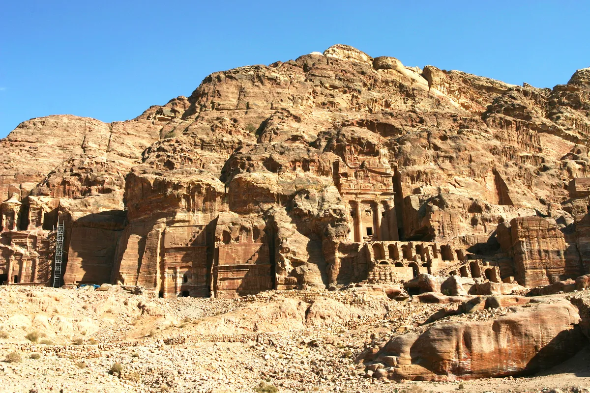 Royal tombs carved into the red sandstone cliffs of Petra under a blue sky