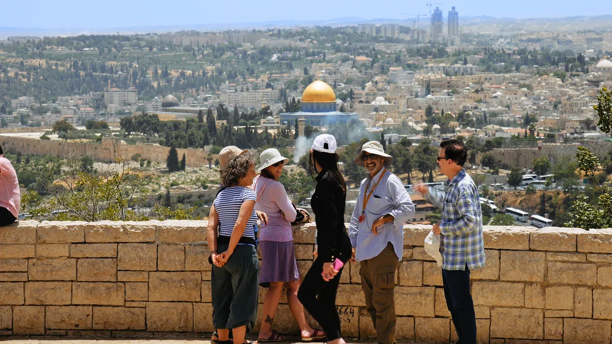 A tour group on the Mount of Olives, looking over Jerusalem's Old City and the Dome of the Rock